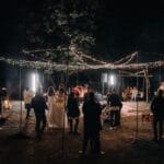 Wieczorne przyjęcie weselne w plenerze wśród girland świetlnych